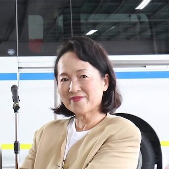 救急車「HARUMIMI号」の前で笑顔を見せる寄贈者の原谷治美様